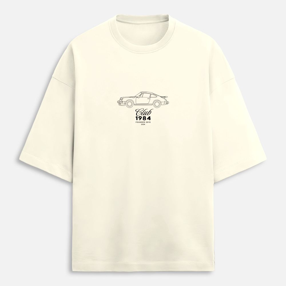 Beige t-shirt with a car graphic and text on a light gray background