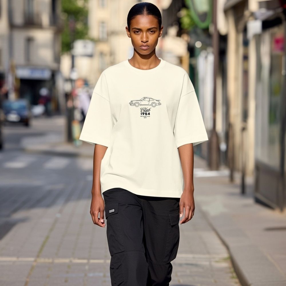 Person wearing a white t-shirt with a graphic design on a city street