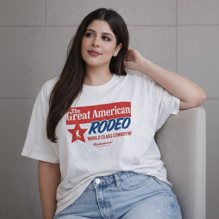 Woman wearing a white t-shirt with 'The Great American Rodeo' graphic design.