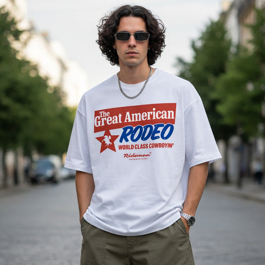 Man wearing a white t-shirt with 'The Great American Rodeo' design outdoors.