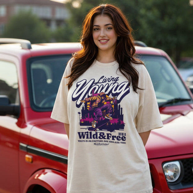 Woman wearing a 'Living Young Wild & Free' t-shirt in front of a red vehicle.