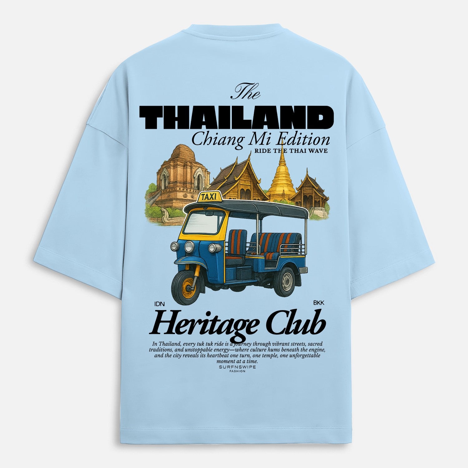 Light blue t-shirt with a graphic of a tuk-tuk and Thai architecture on the back, featuring text about Thailand and Chiang Mai.