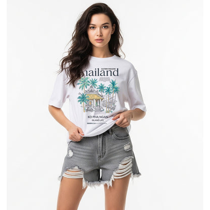 Woman wearing a white t-shirt with a graphic design and ripped denim shorts on a white background