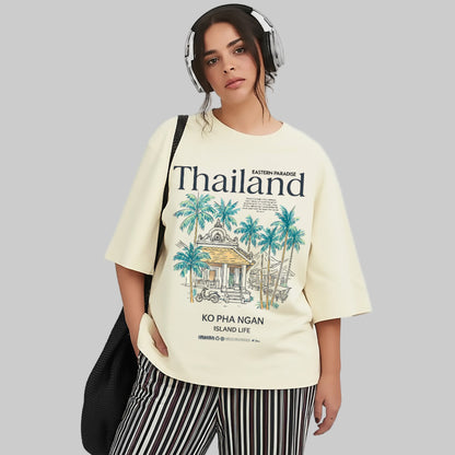 Person wearing a cream-colored t-shirt with 'Thailand' and palm tree design on a white background