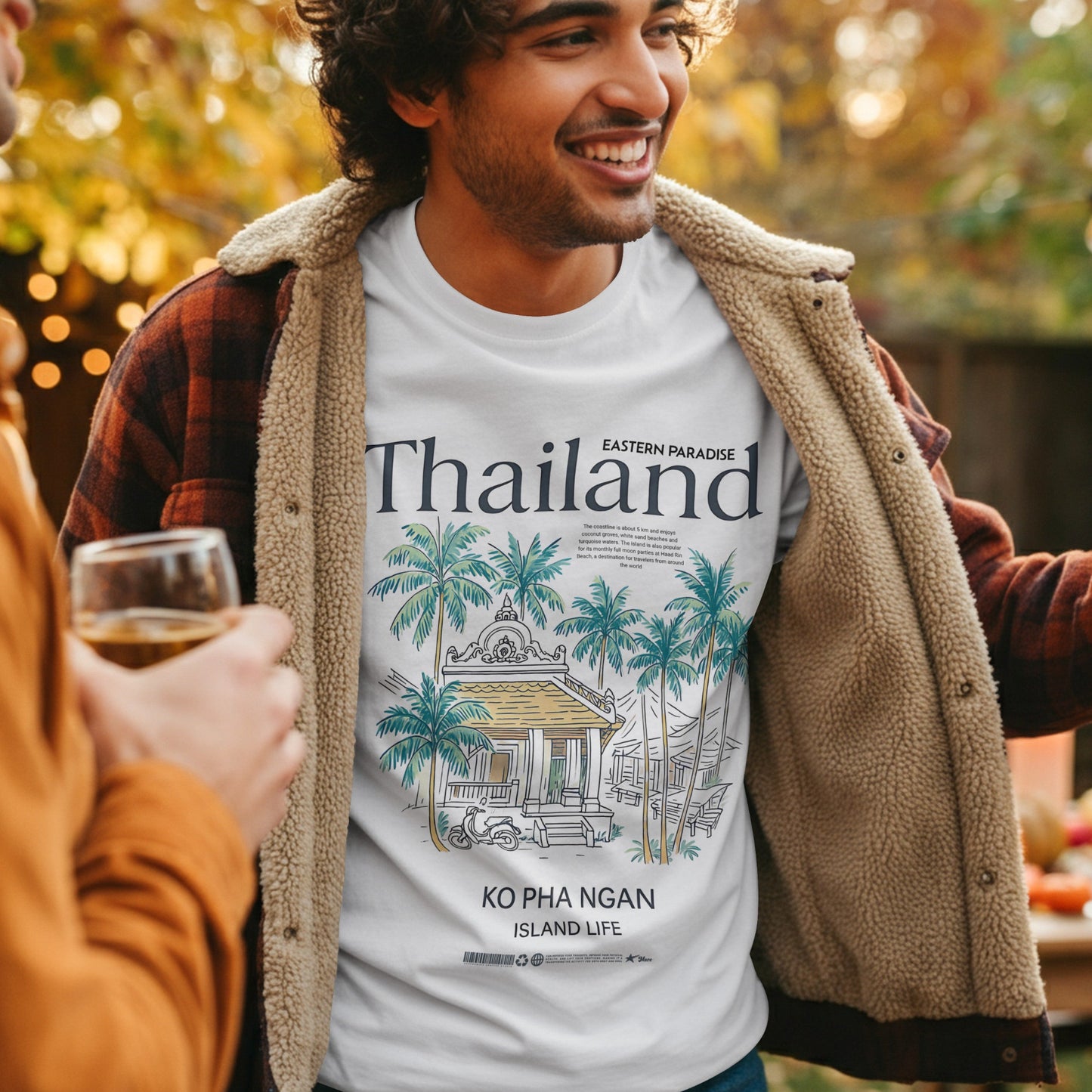Man wearing a 'Thailand' t-shirt with a scenic design, standing outdoors with another person.