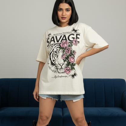 Woman wearing a white t-shirt with a graphic design of a tiger and roses, standing against a gray background.