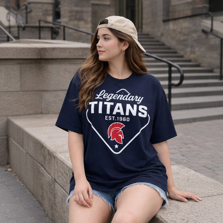 Woman wearing a navy blue t-shirt with 'Legendary Titans' design, sitting on steps.