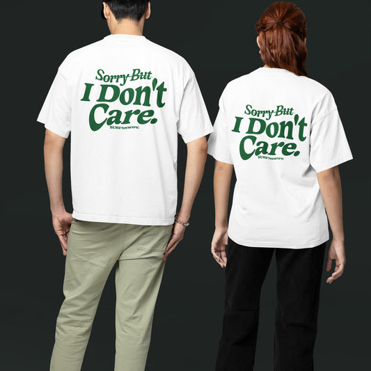 A man and a woman wearing white oversized tees with green text graphic on the front.