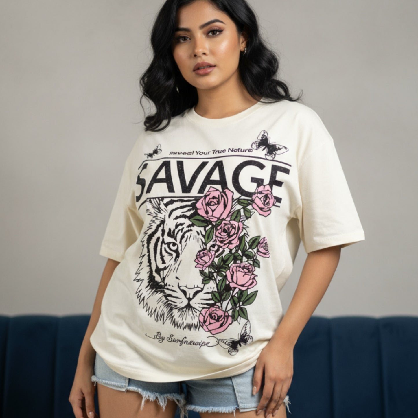 Woman wearing a white t-shirt with a graphic design featuring a tiger, roses, and the word 'SAVAGE'.