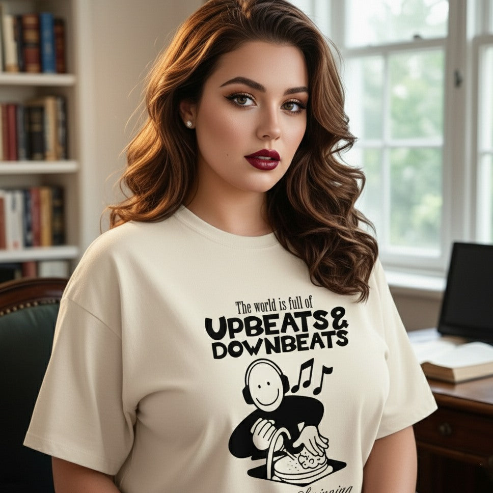 Woman wearing a t-shirt with a graphic design and text in a room with books and a window.