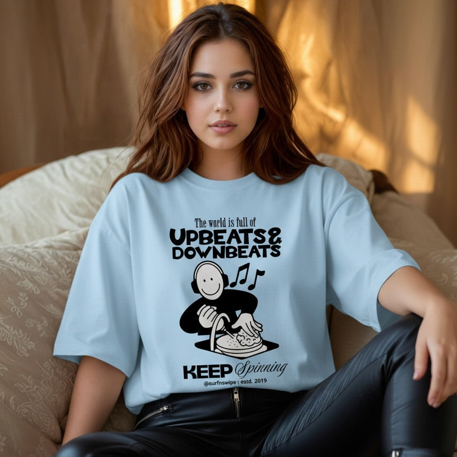 Woman wearing a light blue t-shirt with a graphic design and text.