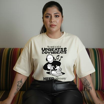 Woman wearing a t-shirt with a graphic design and text, sitting on a colorful couch.