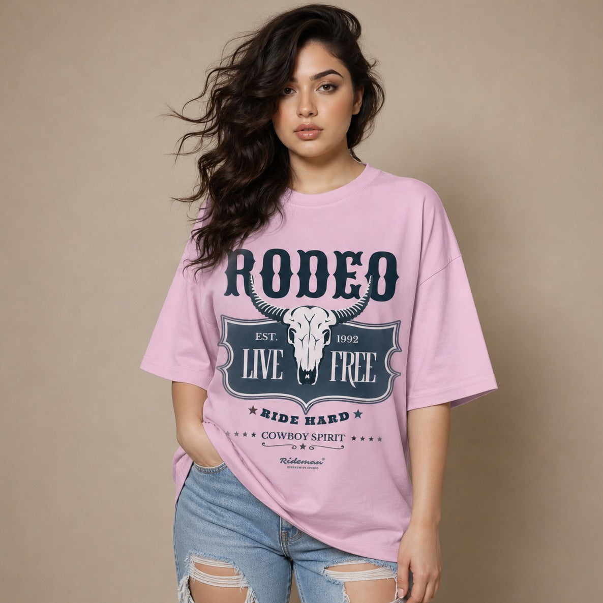 Woman wearing a pink t-shirt with 'Rodeo Live Free' design on a beige background