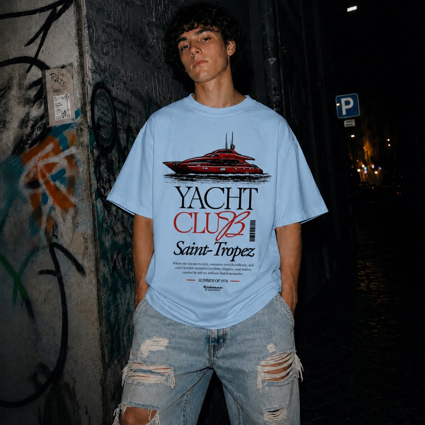 Man wearing blue Yacht Club Saint-Tropez oversized tee with ripped denim jeans