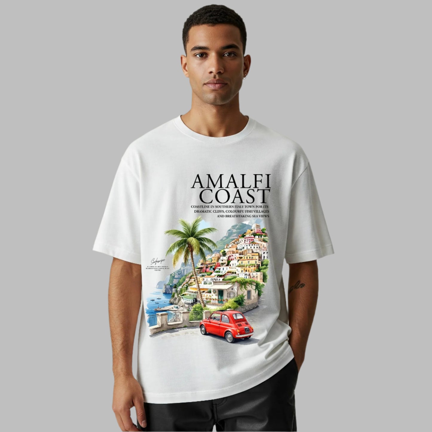 Person wearing a white t-shirt with 'Amalfi Coast' design featuring a scenic view and red car.