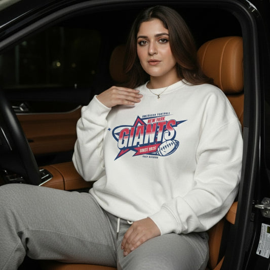 Woman wearing a white sweatshirt with a sports team logo, sitting inside a car.