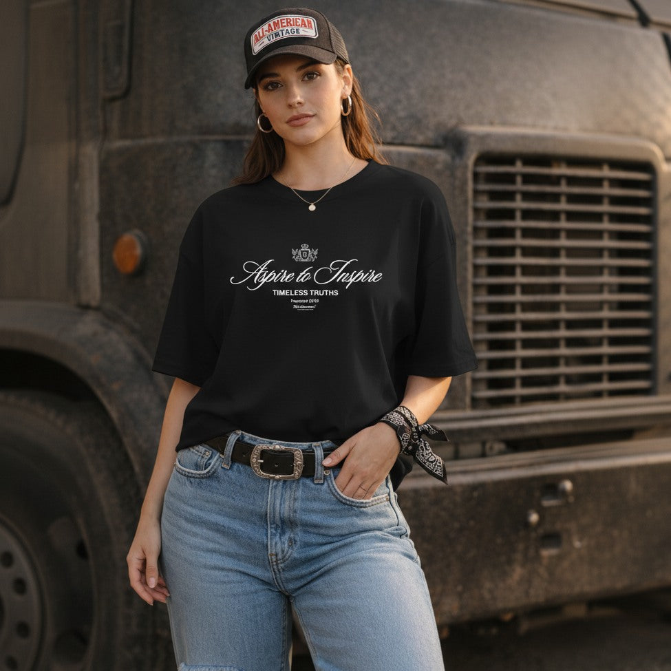 Woman wearing a black t-shirt with text and graphics, standing in front of a large truck.