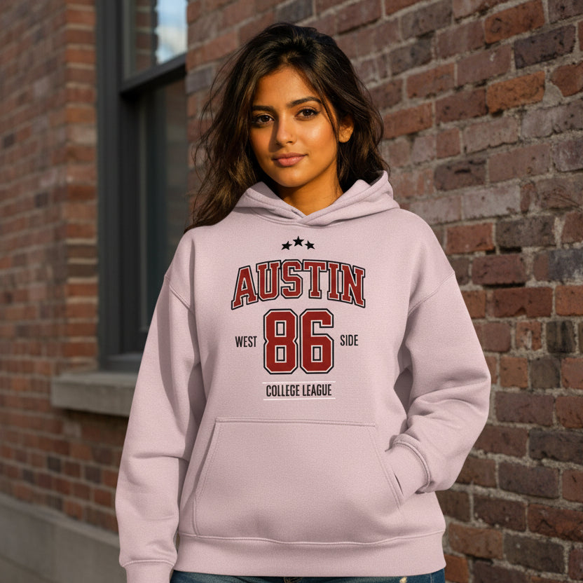 Person wearing a light purple hoodie with 'Austin 86' text, standing outdoors.