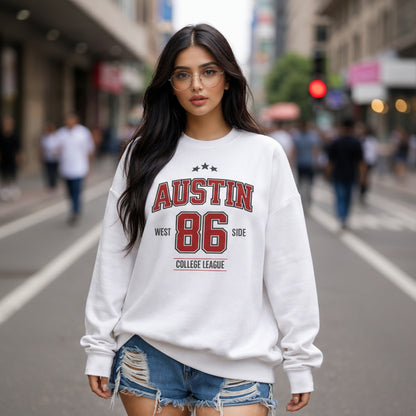 Woman wearing a white sweatshirt with 'Austin 86' text on a city street.