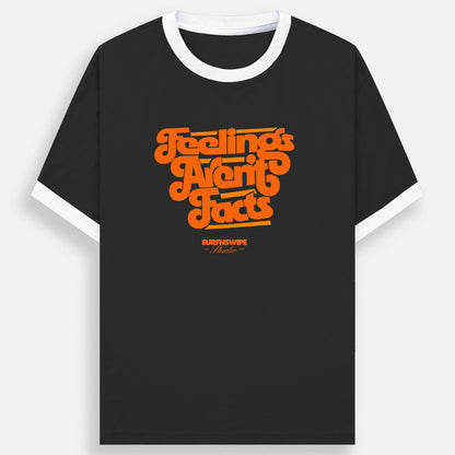 A black ringer t-shirt with a white crew neck and white sleeve cuffs, featuring a retro orange graphic on the chest that reads 'Feelings Are Facts' with 'SURFNSWIPE Apparel' printed below it.
