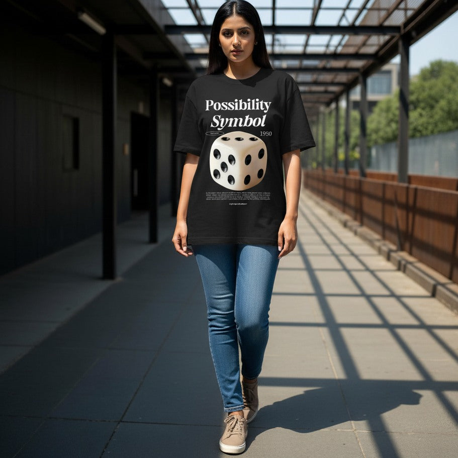 Woman wearing a black t-shirt with a dice graphic and text, standing on a covered walkway.