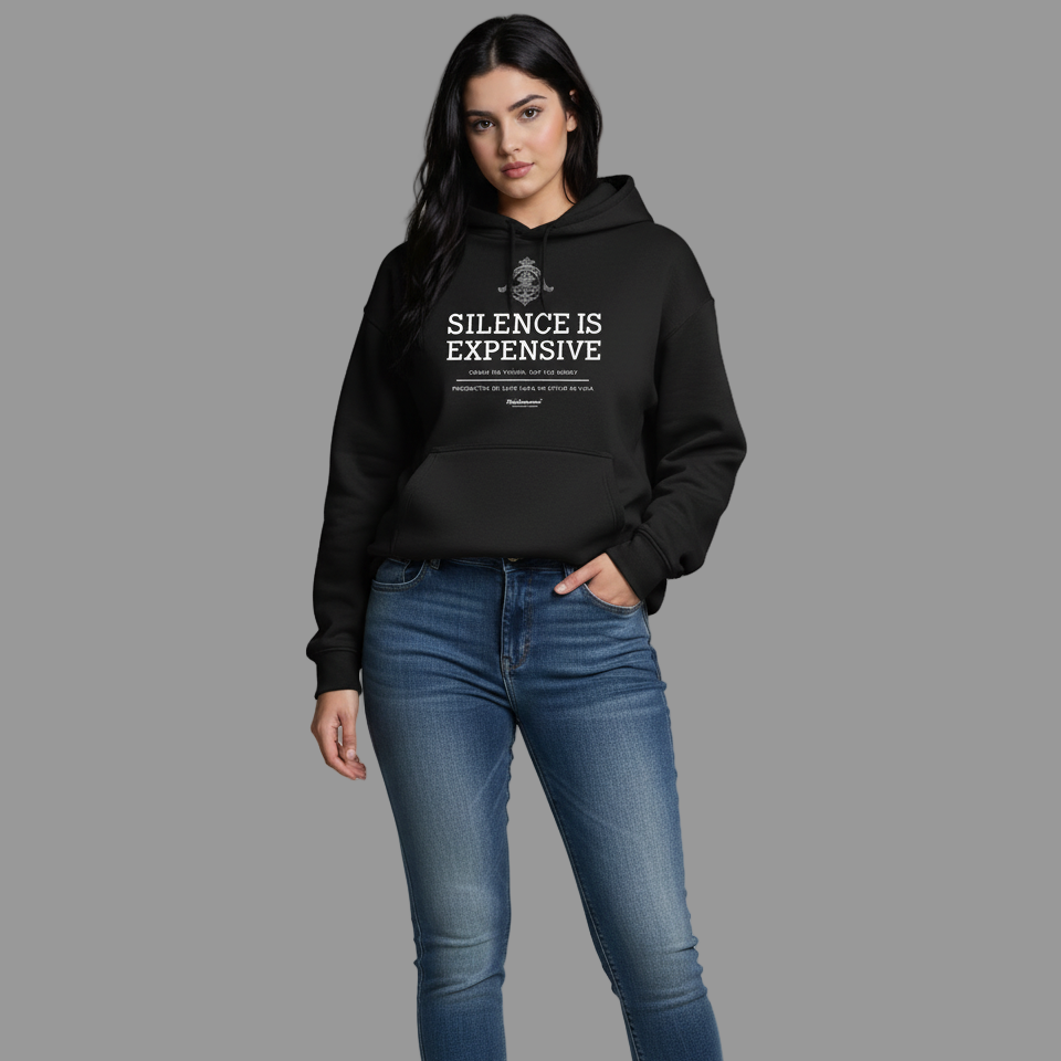 Woman wearing a black hoodie with text and blue jeans on a gray background