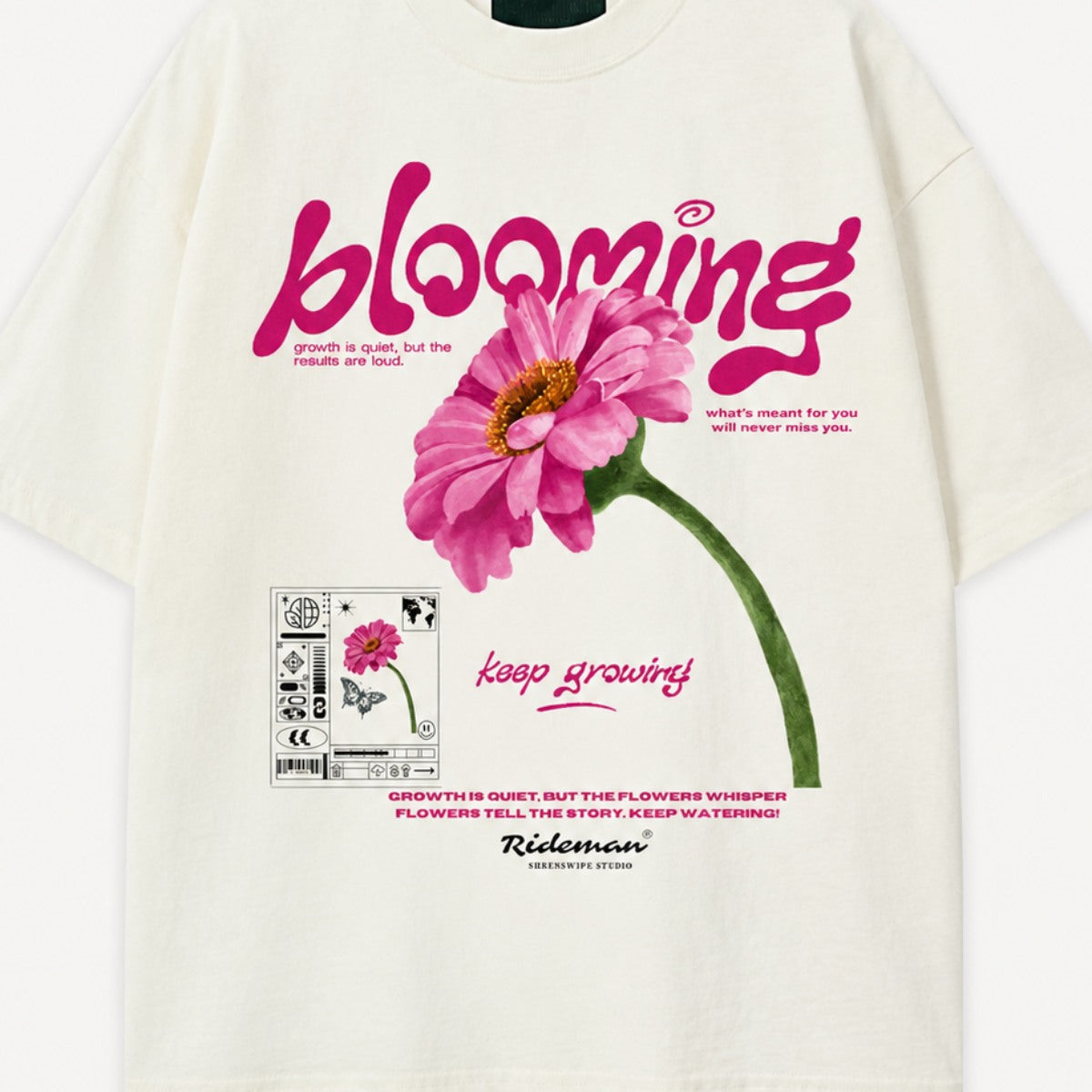White t-shirt with pink flower graphic and 'blooming' text on a white background