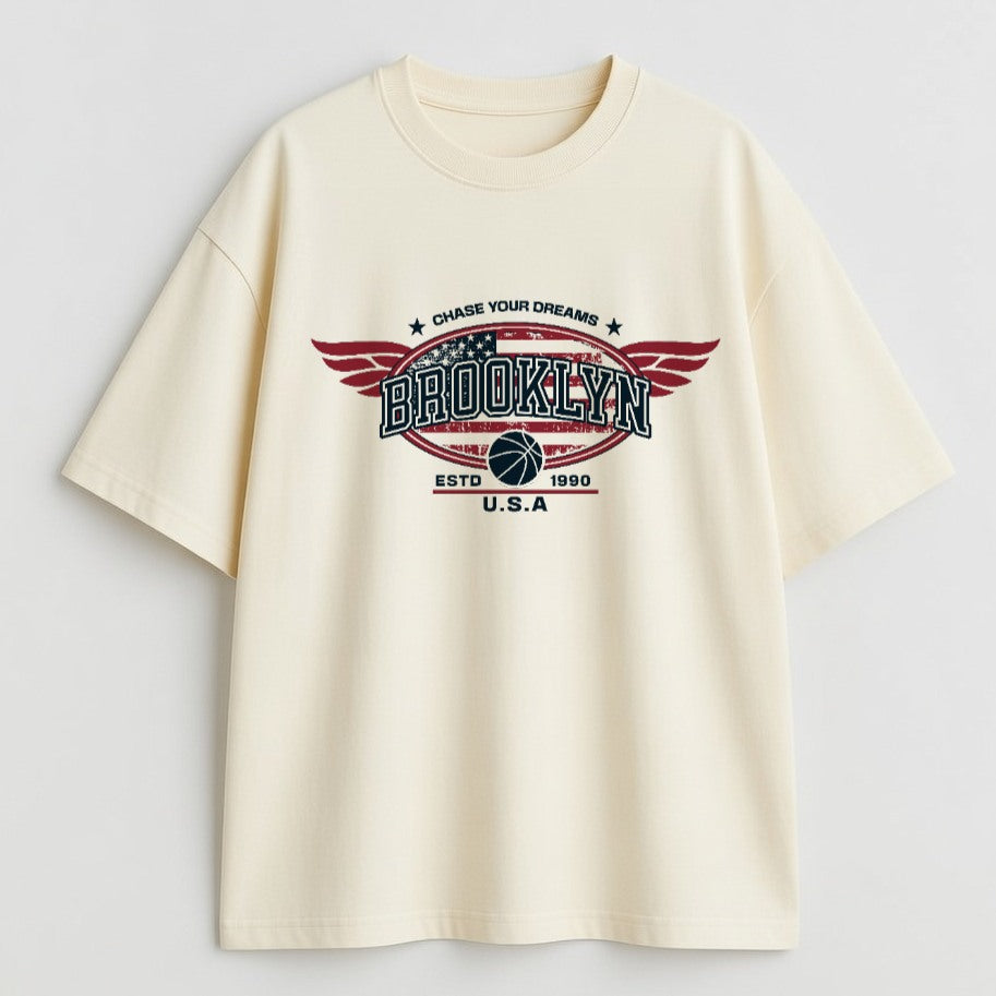 Beige t-shirt with 'Brooklyn' graphic design on a light gray background