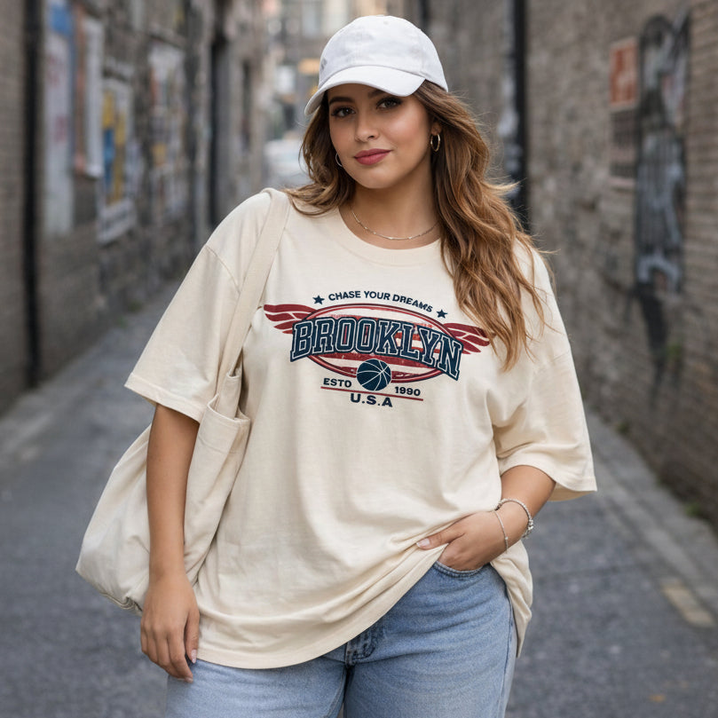 Woman wearing a 'Brooklyn' t-shirt with a cap in an urban setting