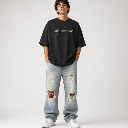 Person wearing a black oversized t-shirt and ripped jeans on a white background