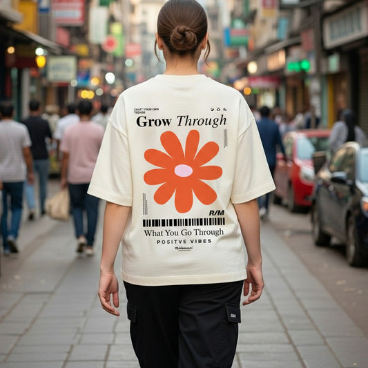 Person wearing a white t-shirt with a red flower graphic and text on a city street.