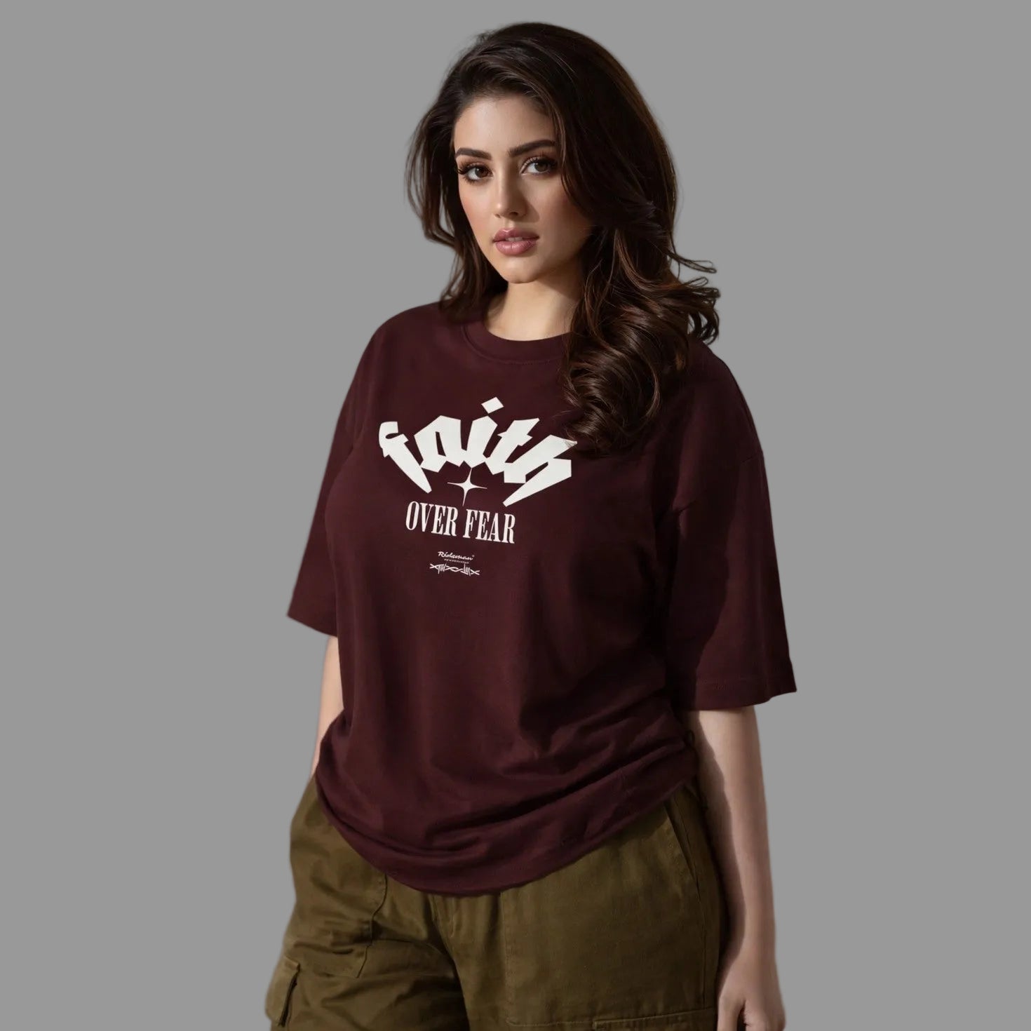 Woman wearing a maroon t-shirt with 'Faith Over Fear' text against a gray background