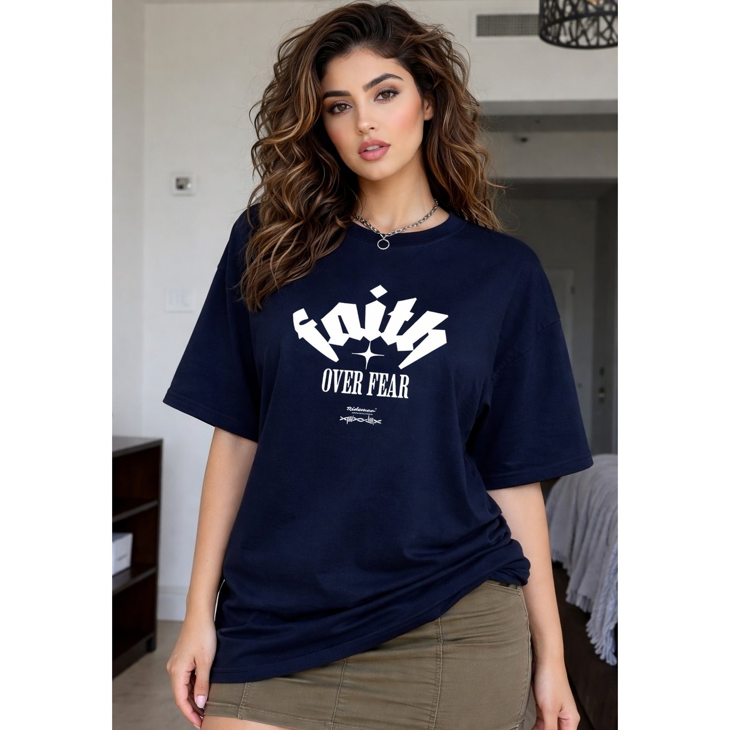 Woman wearing a navy blue t-shirt with 'Faith Over Fear' text in a casual setting.