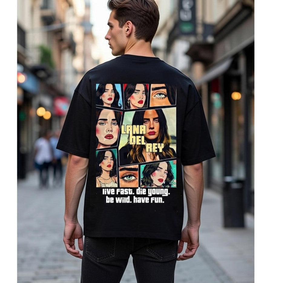 Person wearing a black t-shirt with a graphic design and text on the back, standing on a street.