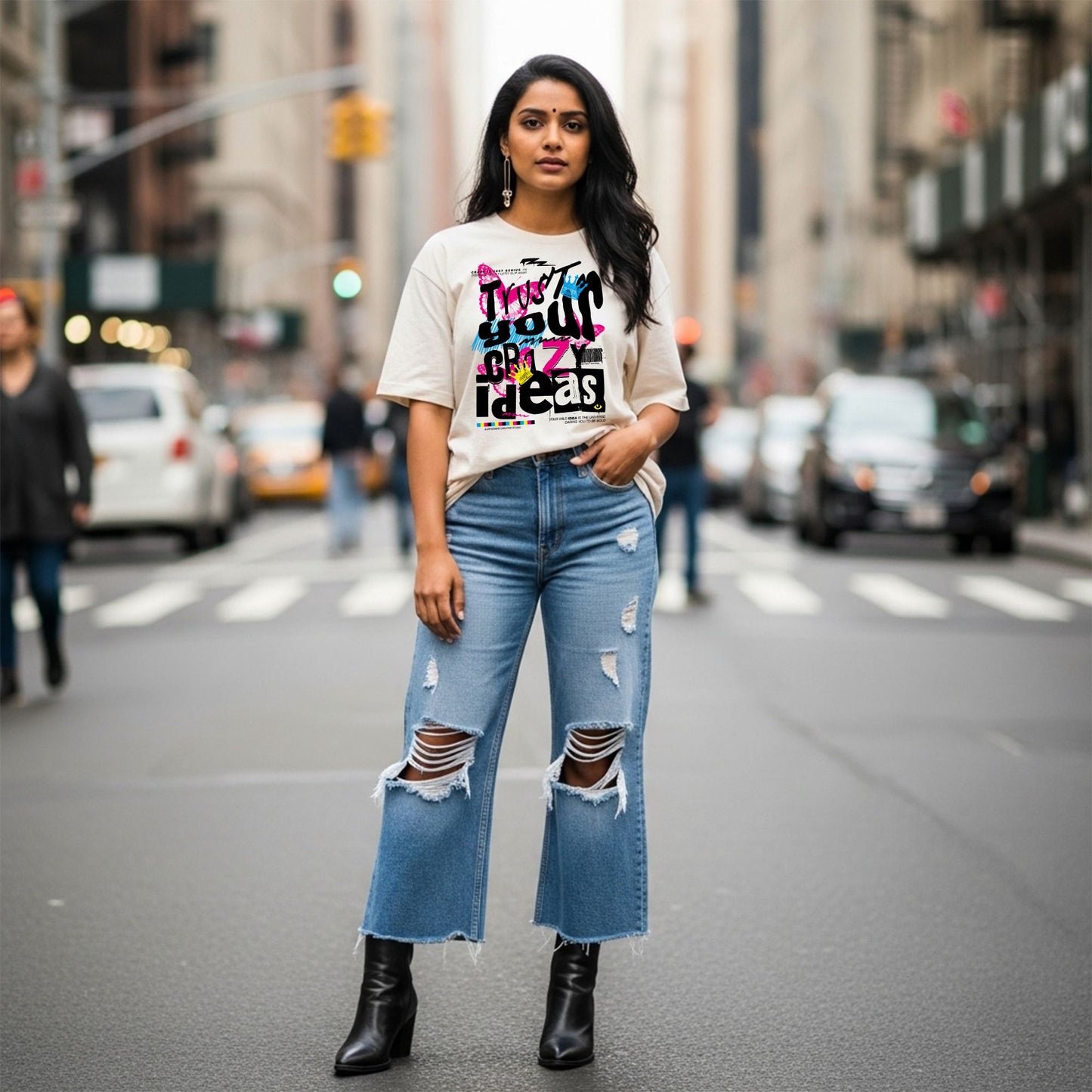 Woman wearing a graphic t-shirt and ripped jeans on a city street.