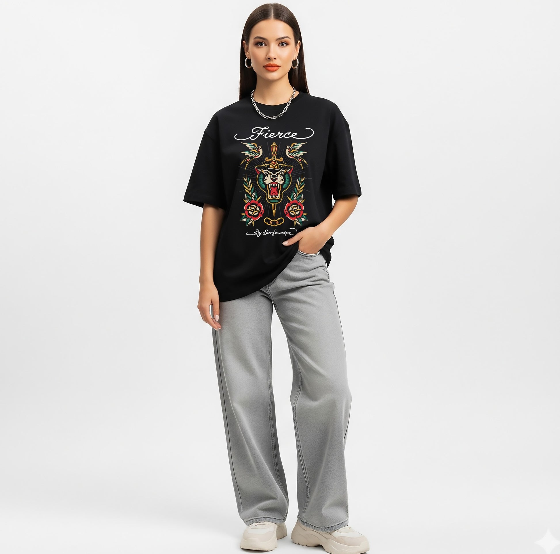 Woman wearing a black t-shirt with a colorful design and text, paired with gray pants on a white background