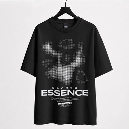 A black short-sleeve t-shirt hanging on a black hanger against a light gray background. The shirt features a large white and gray pixelated graphic of a figure on the chest, with the text 'SACRED ESSENCE' printed in white below it.