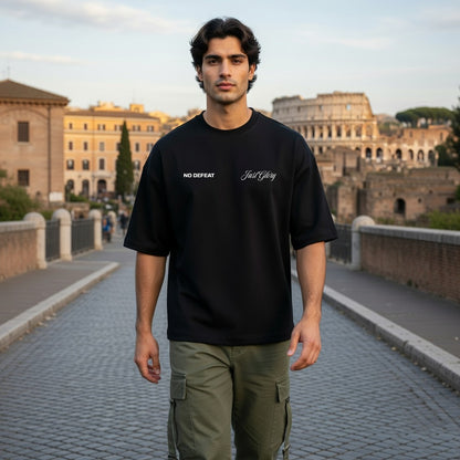 Man wearing a black t-shirt with text standing in front of the Colosseum in Rome.