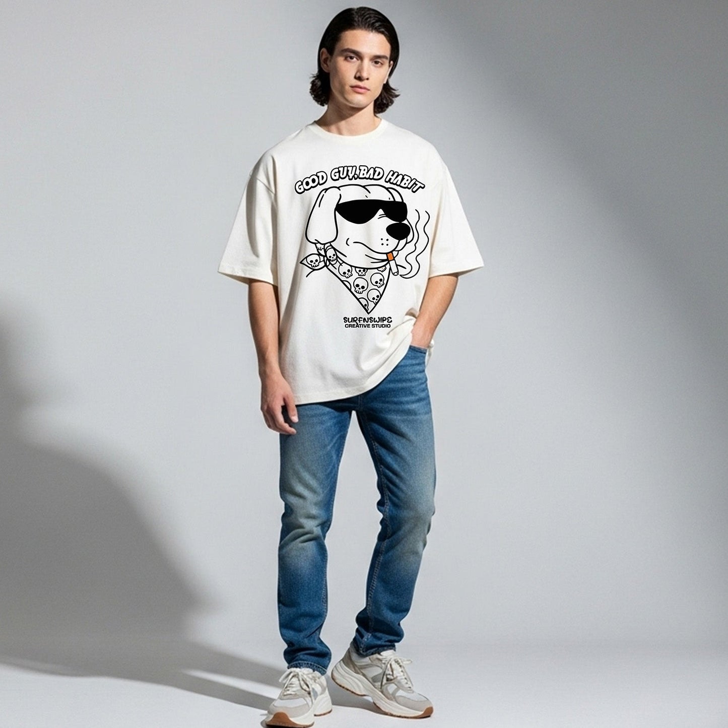 Person wearing a white t-shirt with a graphic design and blue jeans on a gray background