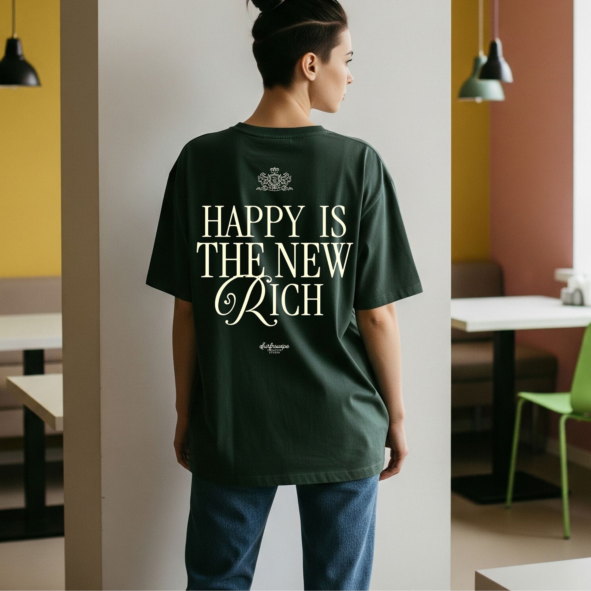Person wearing a green t-shirt with 'Happy is the New Rich' text in a casual setting.