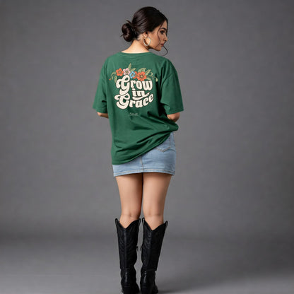 Woman wearing a green t-shirt with 'Grow in Grace' text and floral designs on the back, standing against a gray background.