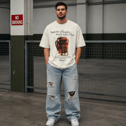 Male model wearing cream Heritage Boxing Glove tee and ripped jeans