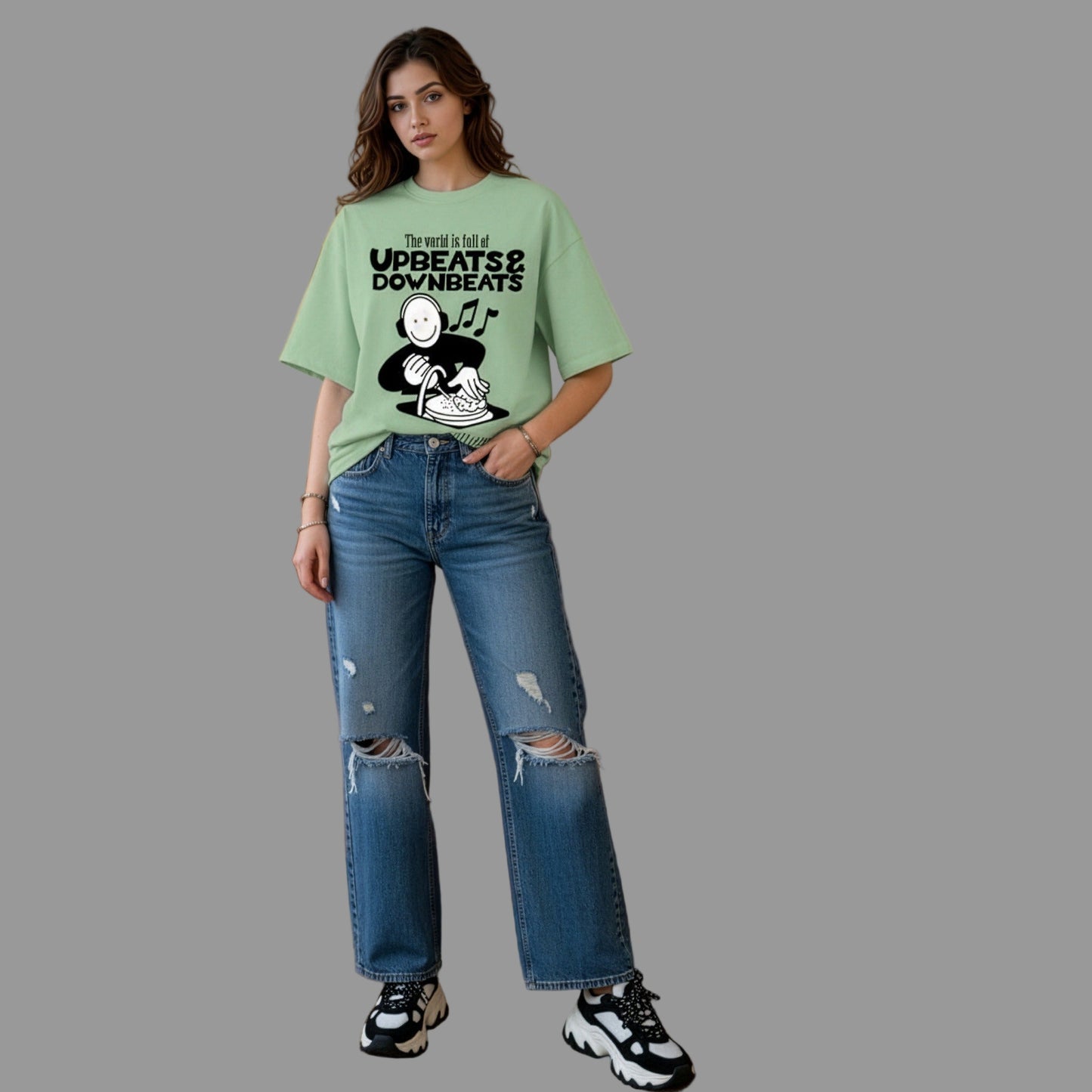 Woman wearing a green t-shirt with text and graphics, standing in a living room.