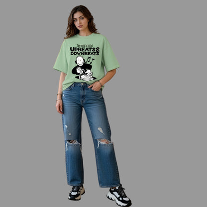 Woman wearing a green t-shirt with text and graphics, standing in a living room.