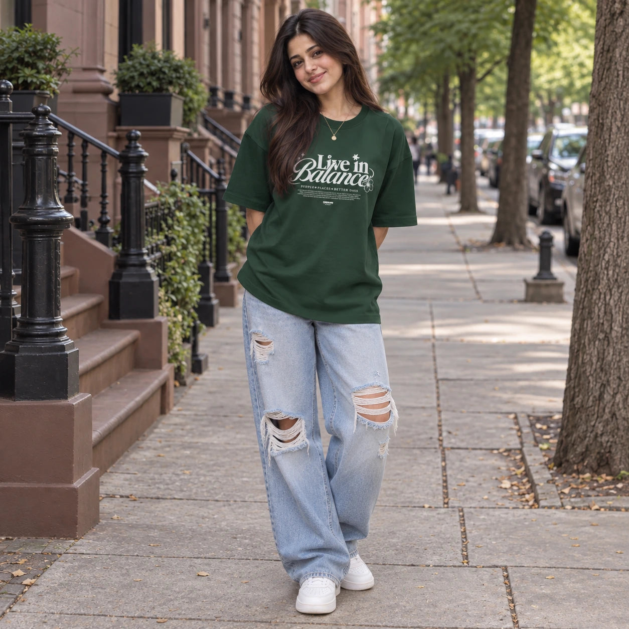 Woman wearing Green oversized boxy fit tee with Live in Balance graphic print