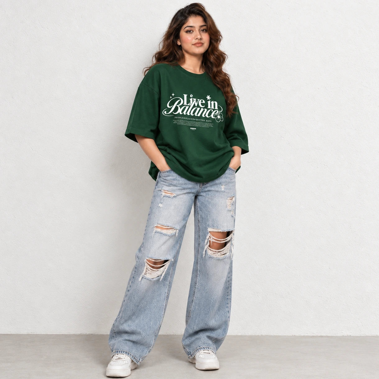 Woman wearing Green oversized boxy fit tee with Live in Balance graphic print