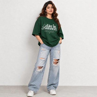 Woman wearing Green oversized boxy fit tee with Live in Balance graphic print