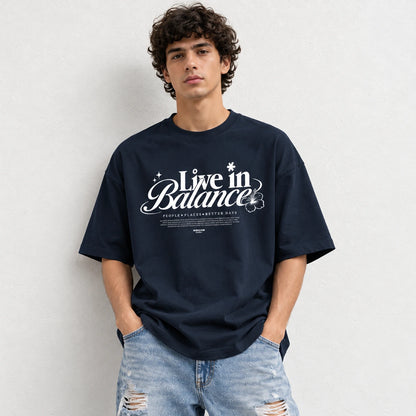 Man wearing Navy oversized boxy fit tee with Live in Balance graphic print