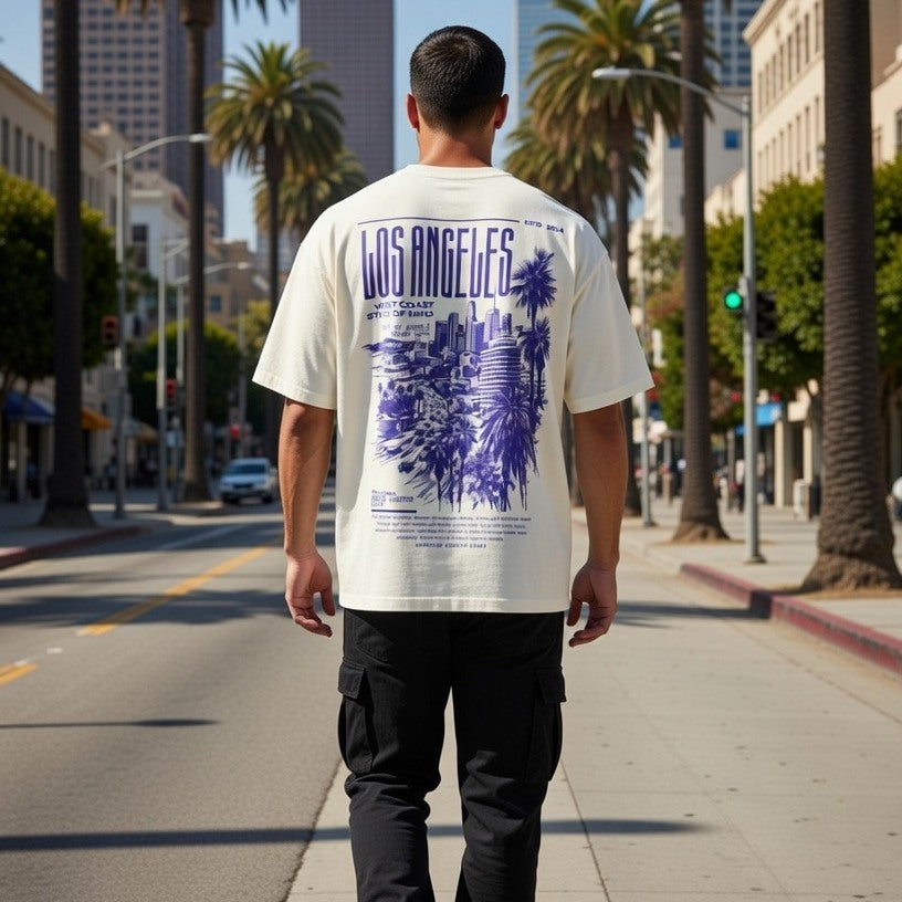 Man walking on a city street wearing a 'Los Angeles' t-shirt with a cityscape design.