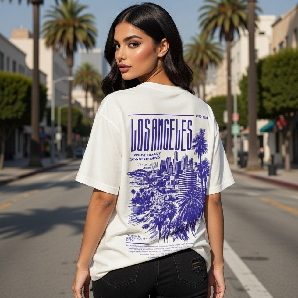 Woman wearing a white t-shirt with 'Los Angeles' design on a city street.